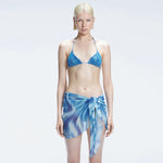 Evita Blue Optical Tie Side Sarong | Moeva | Sarong | Each week unveils new pieces—luxury swimwear, fluid resort silhouettes, and elevated summer-to-evening essentials designed to carry you from coastal escapes to city nights.