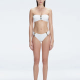"Model wearing the Ilana White Bandeau Bikini Set with buckle and ruched detailing, posing by the pool."
