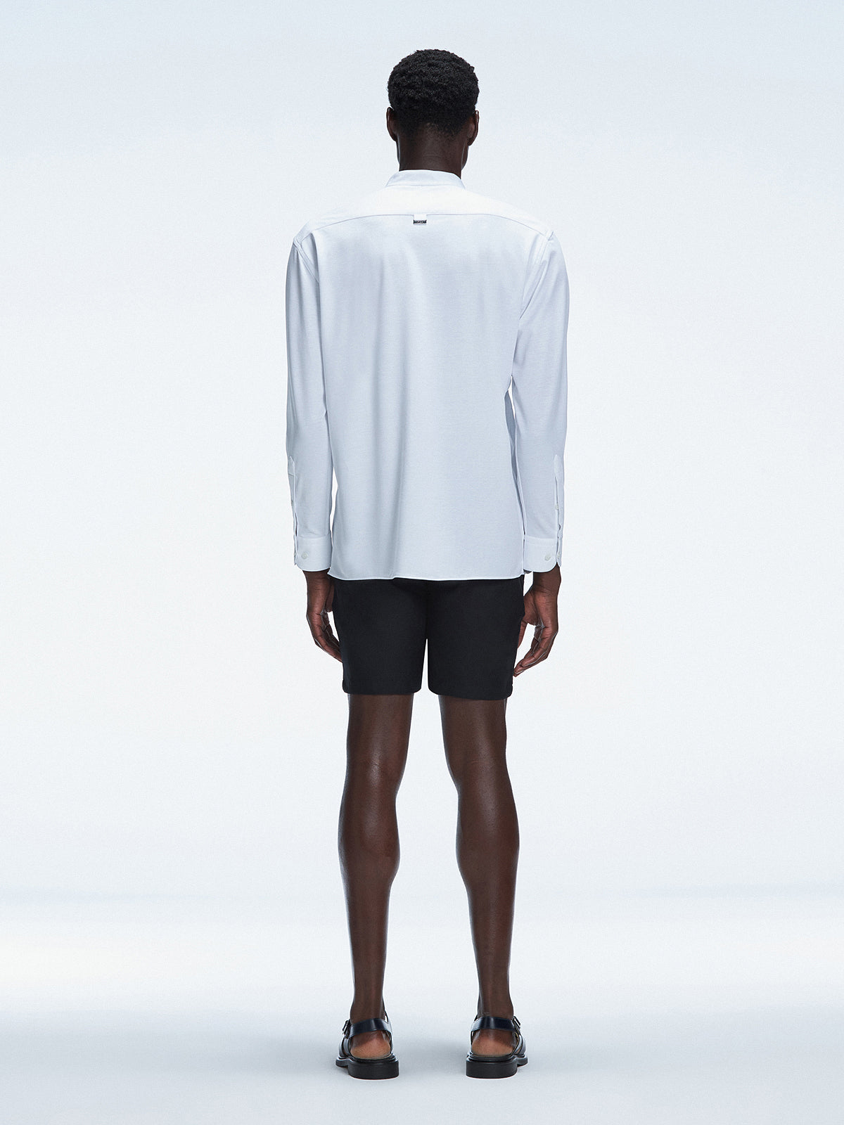 Back view of the Lucius White Shirt’s button fastening and sleek mandarin collar, displayed on a hanger.