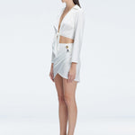 Greta White Long Sleeve Tie Front Shirt and Antonia White High-Waist Wrap Mini Skirt | Moeva | Set | Each week unveils new pieces—luxury swimwear, fluid resort silhouettes, and elevated summer-to-evening essentials designed to carry you from coastal escapes to city nights.