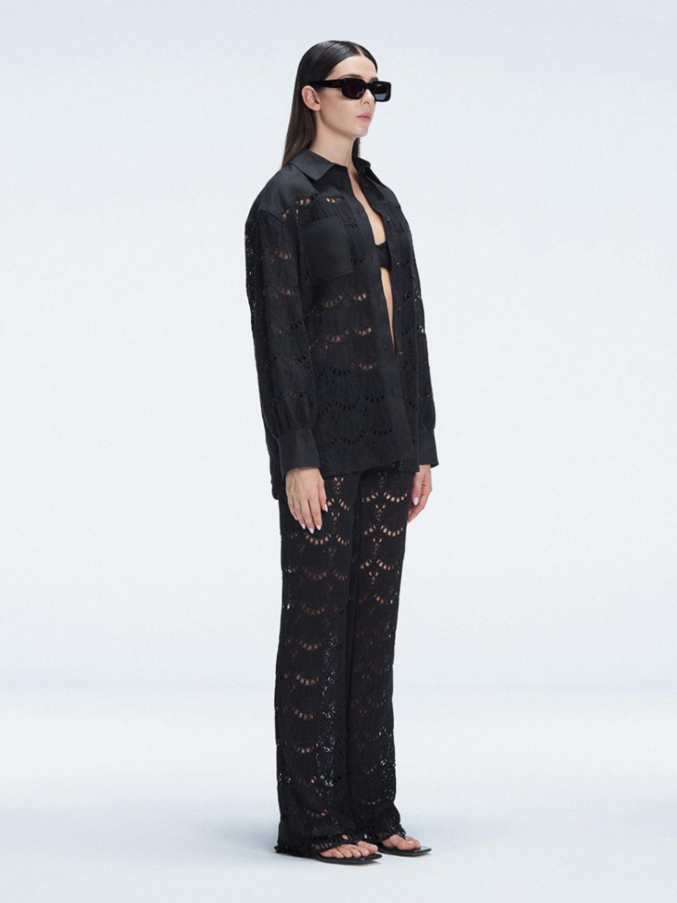 Side view of model showcasing the sleek long-sleeved design of the Nola Black Shirt and Elysia Pants.