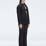 Side view of model showcasing the sleek long-sleeved design of the Nola Black Shirt and Elysia Pants.