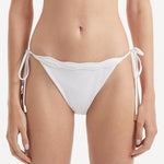 Salila White Side Tie Wave Textured Bikini Bottom | Moeva | Bikini Bottom | Each week unveils new pieces—luxury swimwear, fluid resort silhouettes, and elevated summer-to-evening essentials designed to carry you from coastal escapes to city nights.