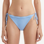 Salila Baby Side Tie Wave Textured Blue Bikini Bottom | Moeva | Bikini Bottom | Each week unveils new pieces—luxury swimwear, fluid resort silhouettes, and elevated summer-to-evening essentials designed to carry you from coastal escapes to city nights.