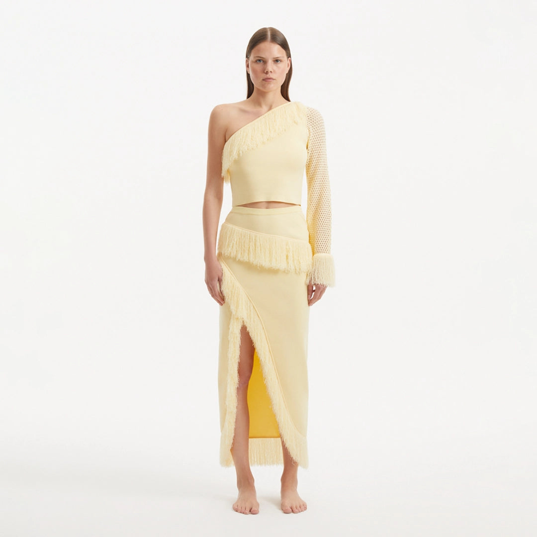 Monroe Yellow One-Shoulder Knit Top with Fringe & Mesh Sleeve | Moeva | Crop Top | Each week unveils new pieces—luxury swimwear, fluid resort silhouettes, and elevated summer-to-evening essentials designed to carry you from coastal escapes to city nights.