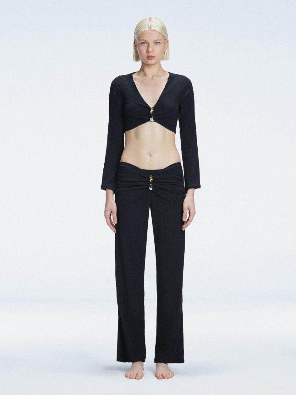 Front view of model wearing Sirenia Black Crop Top and Helena Pants with V-neck, long sleeves, and buckle detail.