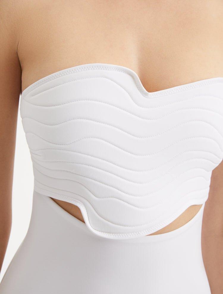 Close-up of Adria White Swimsuit focusing on the wavy texture detailing and adjustable straps. The premium Italian fabric and stylish design elements are featured, emphasizing the blend of elegance and functionality.
