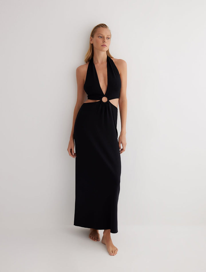 Front View: Model in Clemence Black Dress - MOEVA Luxury Swimwear, Knitted Dress, Halterneck, Side Cutouts, Ring Connecting Top to the Skirt, Ankle Length, Close Fit, MOEVA Luxury Swimwear