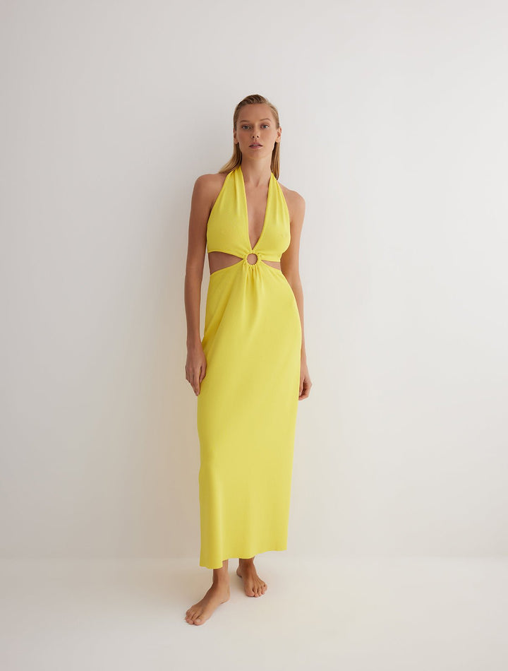 Front View: Model in Clemence Yellow Dress - MOEVA Luxury Swimwear, Knitted Dress, Halterneck, Side Cutouts, Ring Connecting Top to the Skirt, Ankle Length, Close Fit, MOEVA Luxury Swimwear