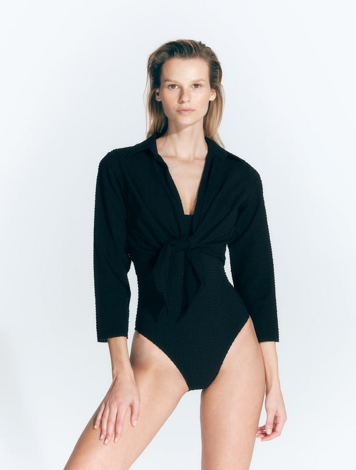 Front View: Model in Greta Black Shirt - MOEVA Luxury Swimwear, Cropped Silhouette, Made of Swimwear Fabric, Tie at the Front, Unlined, Comfort and Day to Night, MOEVA Luxury Swimwear