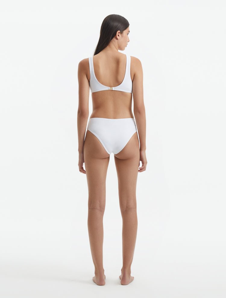 Back View: Model in Honora White Swimsuit - MOEVA Luxury Swimwear, Low Back, Gold Clasps at the Back, Full Bottom Coverage, Fully Lined, MOEVA Luxury Swimwear