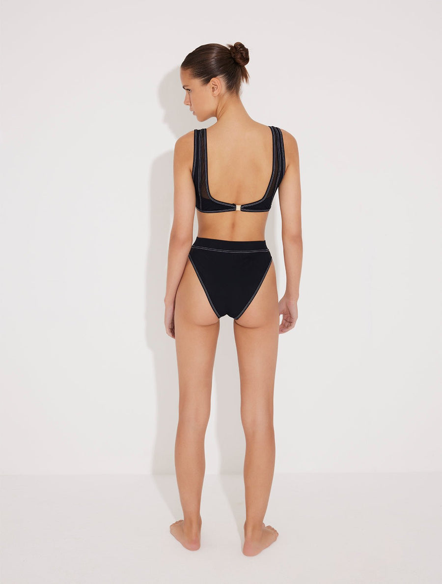 Back View: Model in Ilari Black Bikini Bottom - High-Waisted Swim Bottom, Moderate Bottom Coverage, Lined, Italian Fabric, Special Lycra Xtralife Certificate, MOEVA Luxury Swimwear  