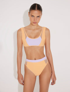 Front View: Model in Ilari Orange/Lilac Bikini Top - MOEVA Luxury Swimwear, Mesh Details, Scoop Neck, Color Contrasting Decorative Stitching Detail, MOEVA Luxury Swimwear 