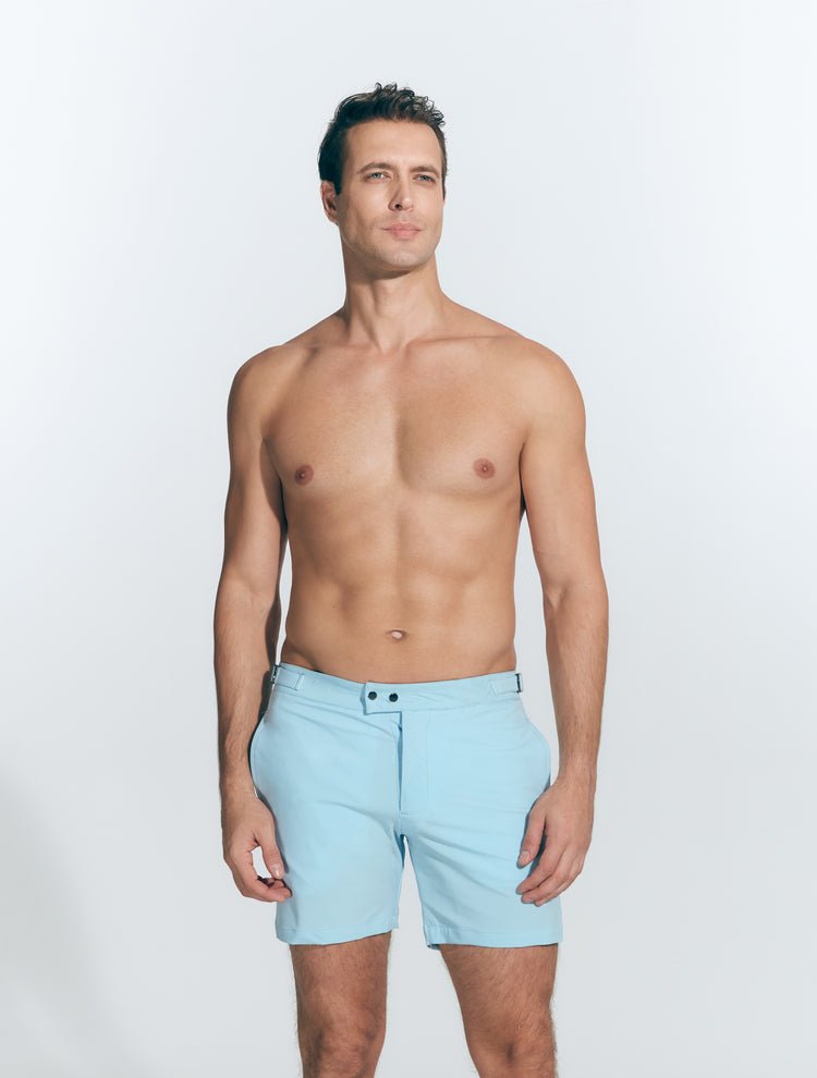 Front View: Model in Jack Baby Blue Shorts - MOEVA Luxury Swimwear, Slim Fitting, Lightweight Fabric with Quick Drying, Front Slash Pockets, Snap and Zip Fastening, Buckles at the Waist, Quick Dry, MOEVA Luxury Swimwear