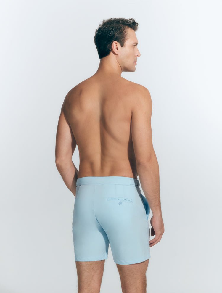 Back View: Model in Jack Baby Blue Shorts - MOEVA Luxury Swimwear, Nikel, Mid Length Swim Shorts, Fully Lined, Slim Fit, Strech Classic,  Buttoned Back Pockets, MOEVA Luxury Swimwear