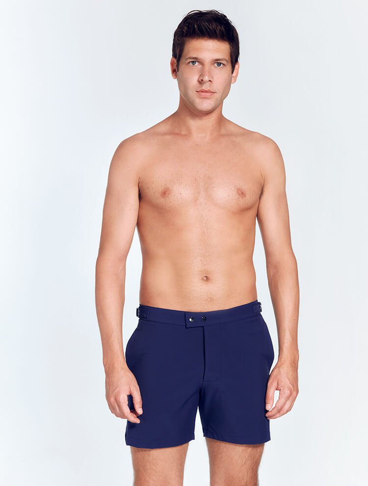 Front View: Model in Jack Navy Blue Shorts - MOEVA Luxury Swimwear, Slim Fitting, Lightweight Fabric with Quick Drying, Front Slash Pockets, Snap and Zip Fastening, Buckles at the Waist, Quick Dry, MOEVA Luxury Swimwear