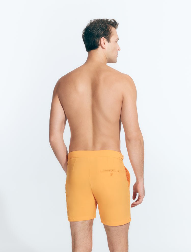 Back View: Model in Jack Orange Shorts - MOEVA Luxury Swimwear, Nikel, Mid Length Swim Shorts, Fully Lined, Slim Fit, Strech Classic,  Buttoned Back Pockets, MOEVA Luxury Swimwear