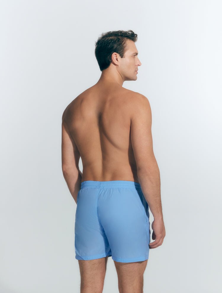 Back View: Model in Louis Baby Blue Shorts - MOEVA Luxury Swimwear, Men Swim Shorts, Nikel, Mid Length Swim Shorts, Fully Lined, Slim Fit, Quick Dry, MOEVA Luxury Swimwear