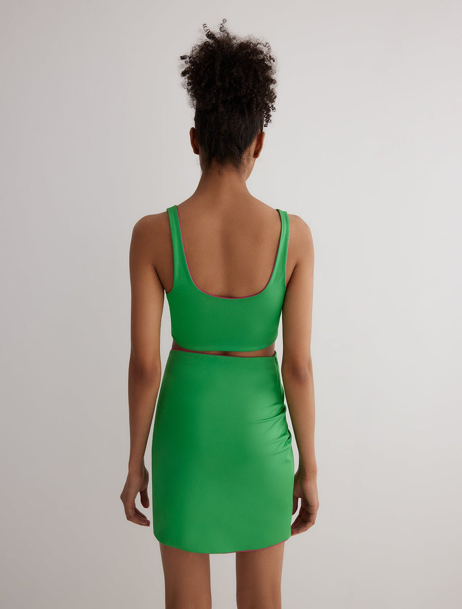 Back View: Model in Lupe Green/Pink Skirt - MOEVA Luxury Swimwear, Mid-Thigh Length, Stretchy Fabric, MOEVA Luxury Swimwear