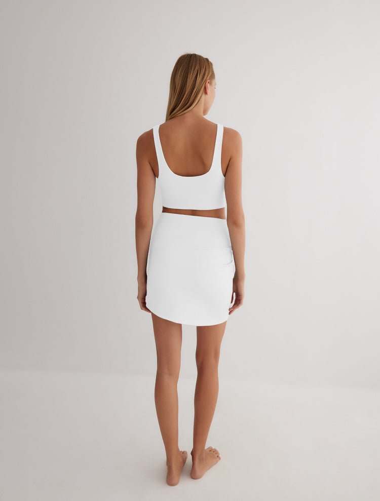 Back View: Model in Lupe Grey/White Skirt - MOEVA Luxury Swimwear, Ready to Wear, Mini Skirt, Unlined, Sportive, Reversible Stretchy Fabric, MOEVA Luxury Swimwear