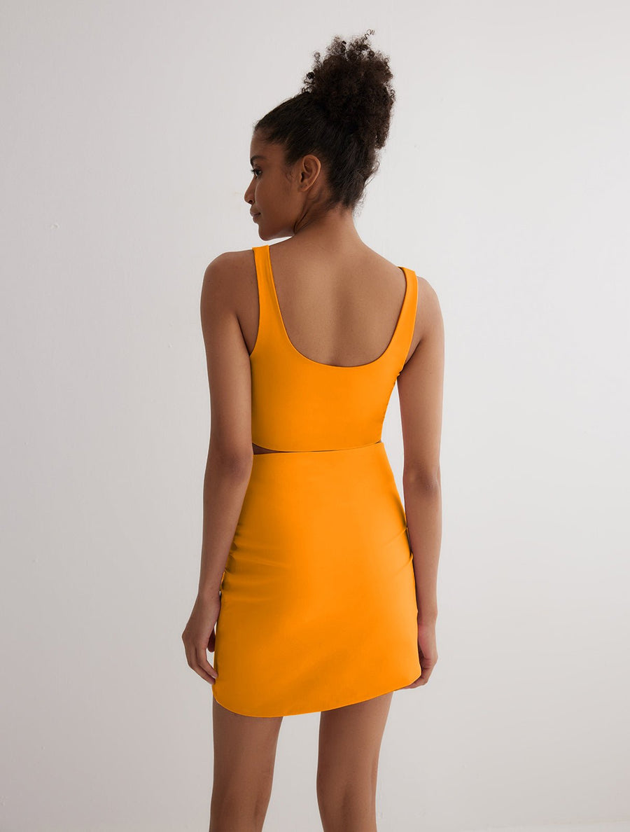 Back View: Model in Lupe Orange/Pink Skirt - MOEVA Luxury Swimwear, Mid-Thigh Length, Stretchy Fabric, MOEVA Luxury Swimwear
