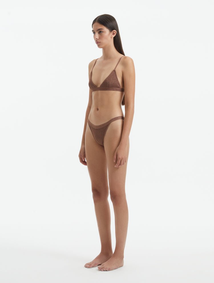 Side View: Model in North Brown Bikini Top - Adjustable Straps, Clasps At The Back, Lined, MOEVA Luxury Swimwear   