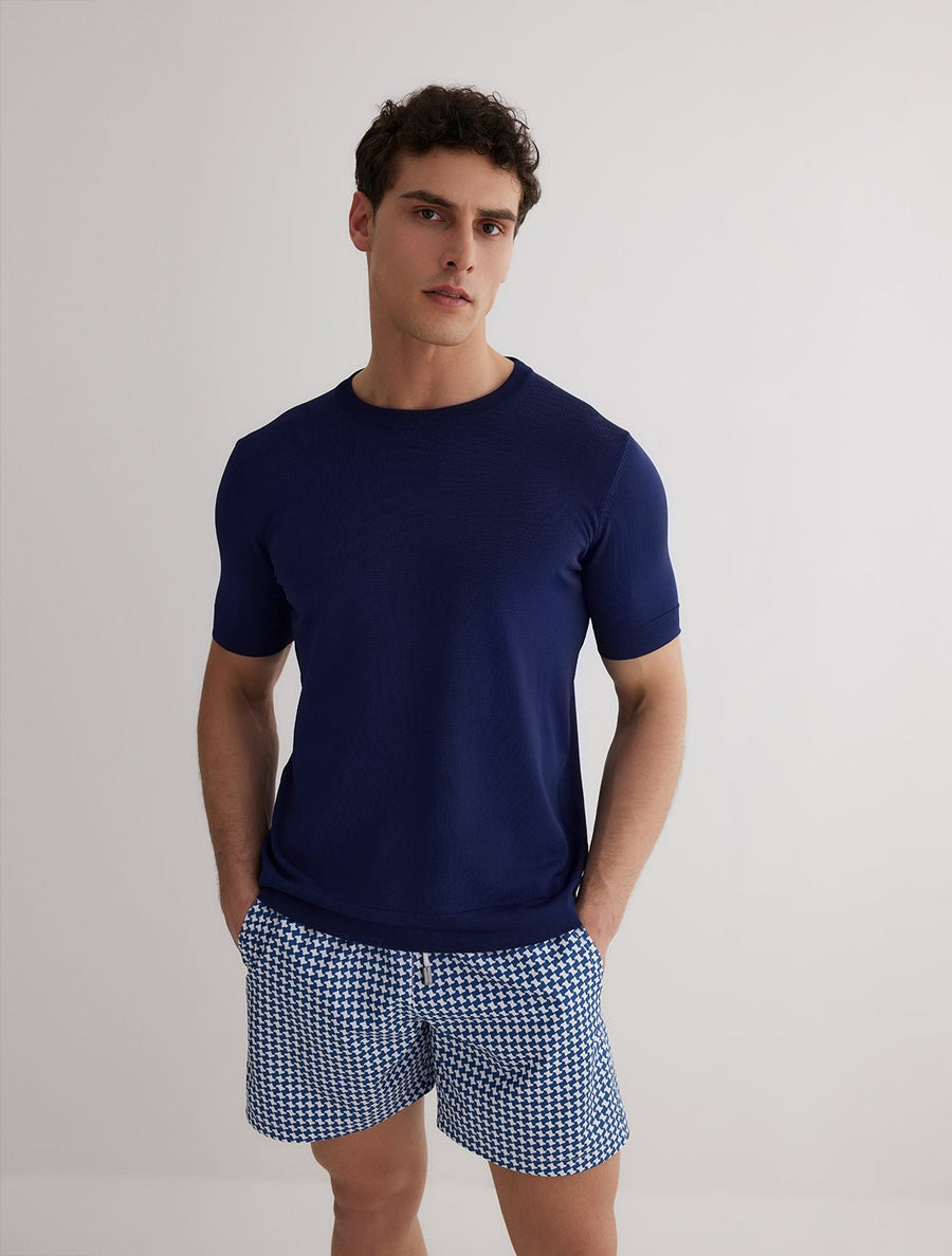 Front View: Model in Oscar Dark Blue T-Shirt - MOEVA Luxury Swimwear, Crew Neckline, Knitted T-Shirt, Short-Sleeved, Slim Fit, MOEVA Luxury Swimwear