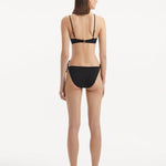 Salila Black Side Tie Wave Textured Bikini Bottom | Moeva | Bikini Bottom | Each week unveils new pieces—luxury swimwear, fluid resort silhouettes, and elevated summer-to-evening essentials designed to carry you from coastal escapes to city nights.