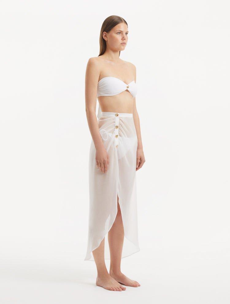 Xander White Sheer Maxi Skirt with Gold Button Details | Moeva | Beachwear Skirts | Each week unveils new pieces—luxury swimwear, fluid resort silhouettes, and elevated summer-to-evening essentials designed to carry you from coastal escapes to city nights.