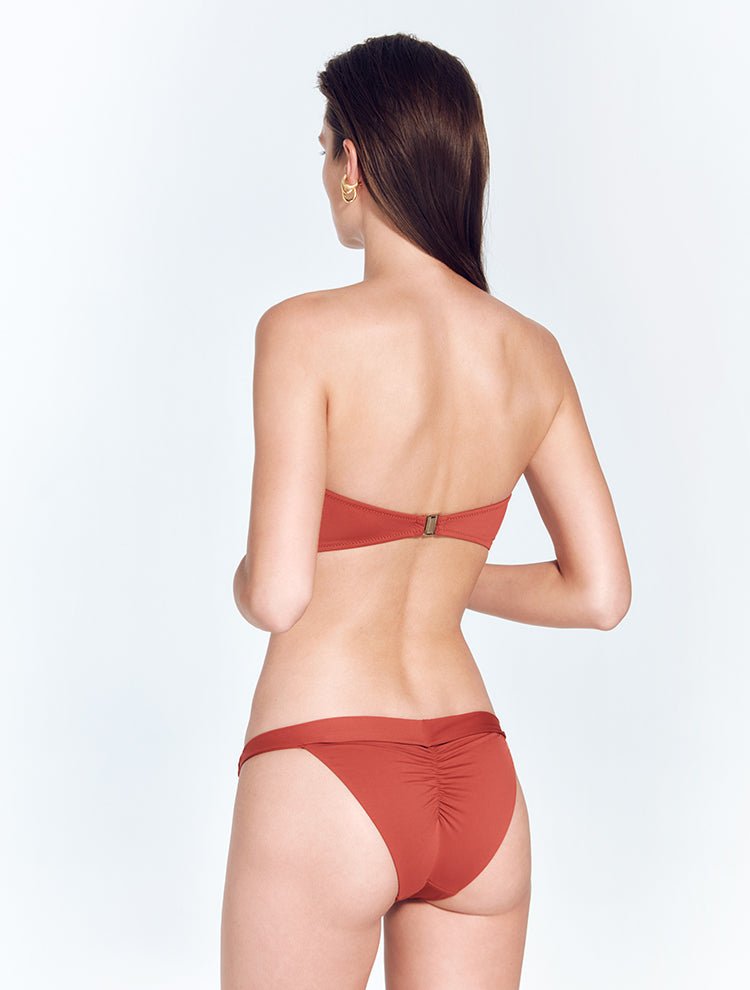Back View: Model in Zeta Red Ochre Bikini Top - MOEVA Luxury Swimwear, Gold Clasps at the Back, Lycra XtraLife® Certificate, Italian Fabric, Strapless Bandeau Bikini Top, MOEVA Luxury Swimwear
