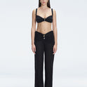 Front view of model wearing Angelique Black High-Rise Pants with layered panel and gold hoop accessory.
