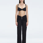 Front view of model wearing Angelique Black High-Rise Pants with layered panel and gold hoop accessory.
