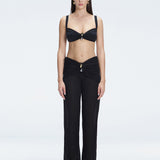 Front view of model wearing Angelique Black High-Rise Pants with layered panel and gold hoop accessory.
