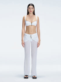 Front view of model wearing Angelique White High-Rise Pants with layered panel and gold hoop accessory.
