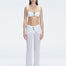 Front view of model wearing Angelique White High-Rise Pants with layered panel and gold hoop accessory.
