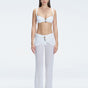 Front view of model wearing Angelique White High-Rise Pants with layered panel and gold hoop accessory.
