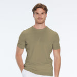 Man wearing a green t-shirt and white pants on a white background