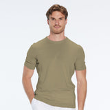 Man wearing a green t-shirt and white pants on a white background