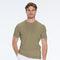 Man wearing a green t-shirt and white pants on a white background