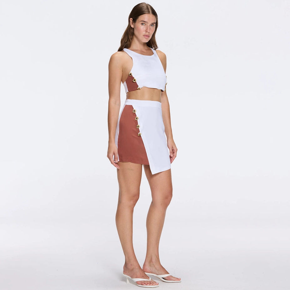 Riviera White-Brown Duo-Colored Asymmetric Gold Button Mini Skort | Moeva | RTW Skirts | Each week unveils new pieces—luxury swimwear, fluid resort silhouettes, and elevated summer-to-evening essentials designed to carry you from coastal escapes to city nights.