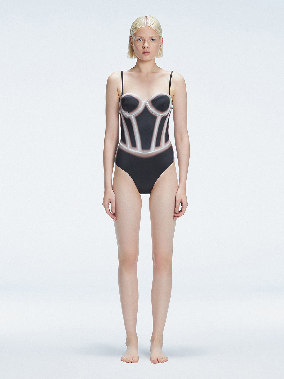 Front view of model wearing Camilla Black Optical Swimsuit with bandeau cut and boned torso for support.
