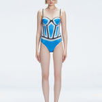 Front view of model wearing Camilla Blue Optical Swimsuit with bandeau cut and boned torso for support.
