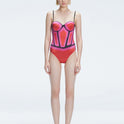 Front view of model wearing Camilla Red Optical Swimsuit with bandeau cut and boned torso for support.
