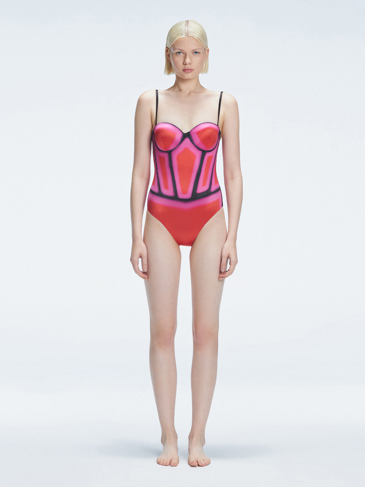 Front view of model wearing Camilla Red Optical Swimsuit with bandeau cut and boned torso for support.
