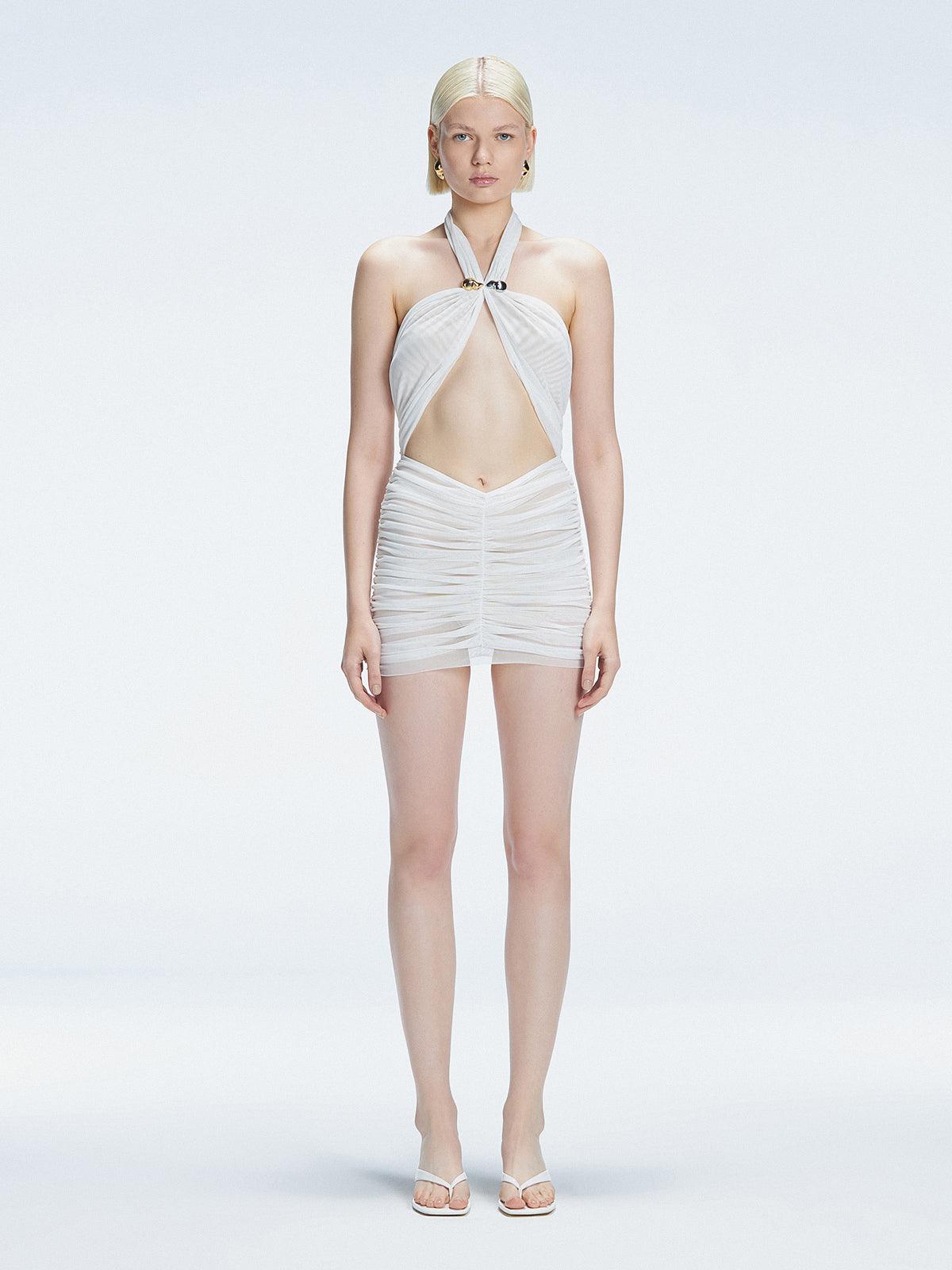 "Model wearing the Carolina White Swimsuit from the front view, featuring a halter neck tie and tulle skirt."
