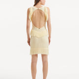 "Model wearing the Diani Yellow Dress from the back, showcasing the low back design with golden clasps."