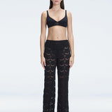 Front view of model wearing Elysia Black Wide-Leg Pants with low-rise fit and hidden side zipper.
