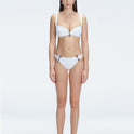 Front view of model wearing Emilia White Bikini Top with bold buckle detail and mesh accents.
