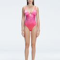 "Model wearing the Gradient Underwired Swimsuit with a ruched front and moderate bottom coverage, standing poolside."
