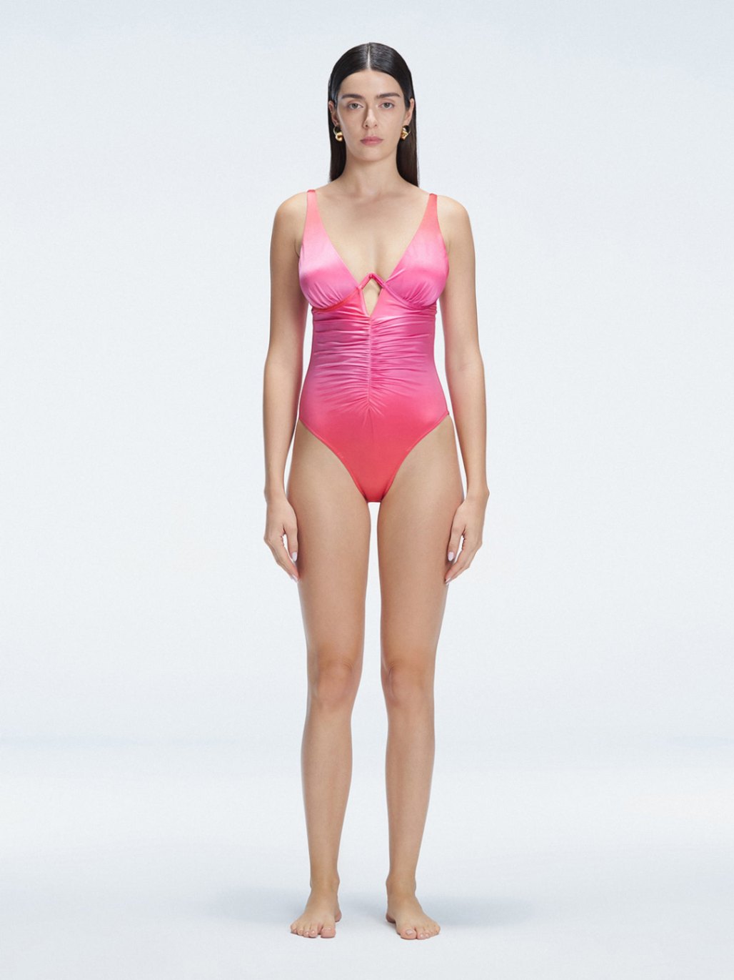 "Model wearing the Gradient Underwired Swimsuit with a ruched front and moderate bottom coverage, standing poolside."
